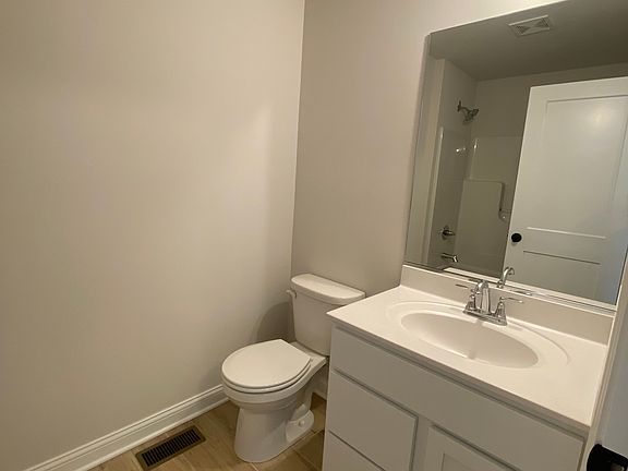Bathroom with lit vanity and mirrors
