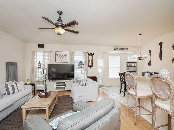 This beautiful and bright living room offers a perfect space to entertain family and friends! Several windows with privacy blinds allow wonderful lighting, high ceilings, dark stained ceiling fan and wood floors.