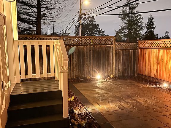Side entrance of ADU with private outdoor space with pavers, lighting and landscaped.