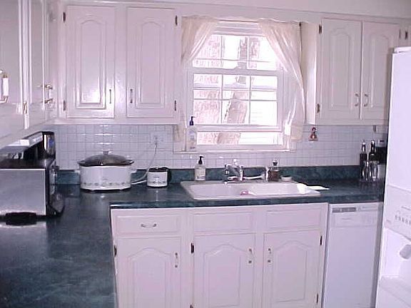 Charming Kitchen with White Cabinets, Appliances and Back Splash