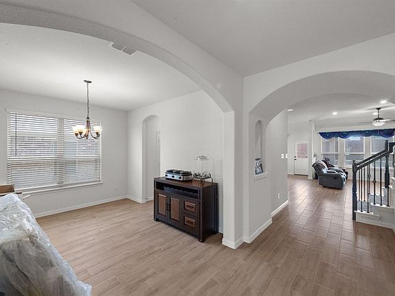 Hall featuring light hardwood / wood-style flooring and a notable chandelier