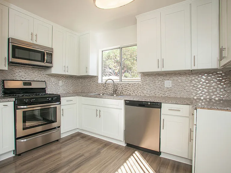 Large kitchen with new cabinets, stainless steel appliances, quartz stone counters, and modern backsplash.