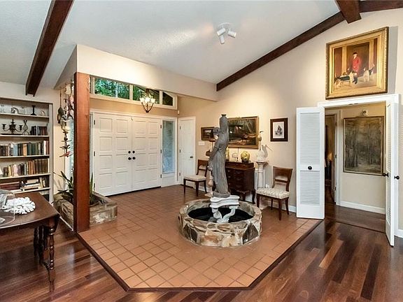 Entryway with vaulted ceiling with beams and wood finished floors