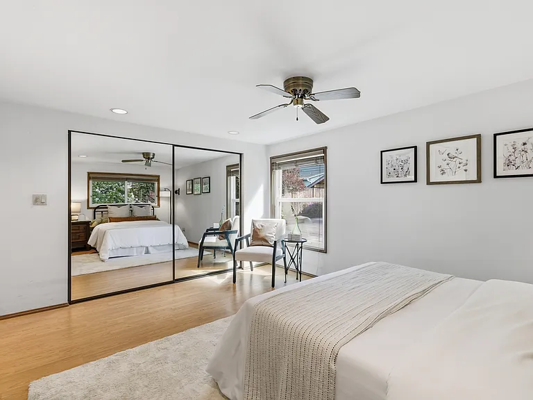 Primary bedroom with mirrored closets and abundant natural light