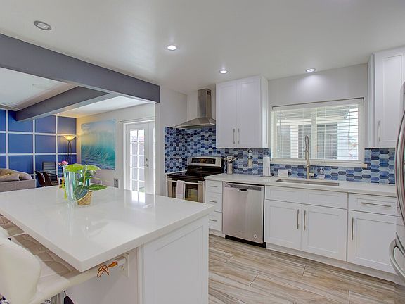 Kitchen opening to living room and patio