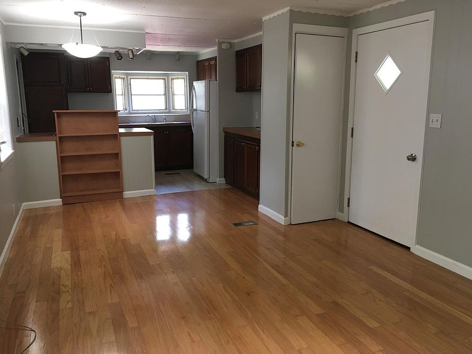view of living room, front door, coat closet, kitchen cabinets