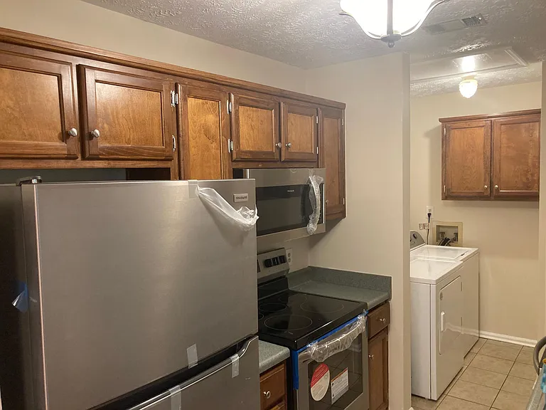 The kitchen features new fixtures and appliances: microwave, ceramic stovetop / range, dishwasher, and refrigerator with ice maker.
