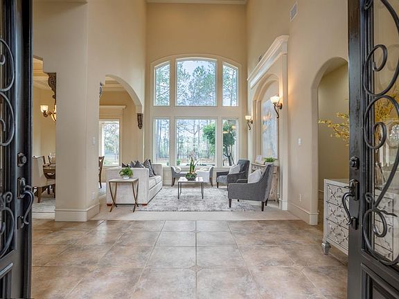 Come on in! Immediately get blown away with the impeccable 10" high wrought iron & glass double doors that welcome you into the home with this amazing view! Your foyer entrance boast with high ceilings & almost floor to ceiling windows giving peacefu