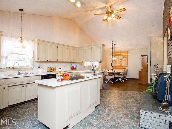 Large kitchen with new stove, new designer lighting, newer dish washer, and an island.