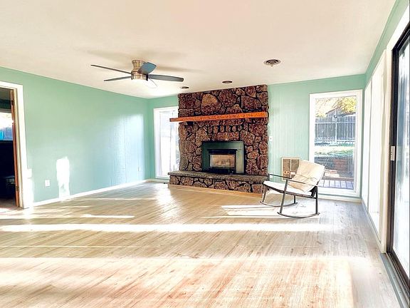 Beautiful and Large Living Room with Lava Rock Fireplace and Mantle. New painted trim around windows, new flooring, new light/fan. More updates have happened since this photo.