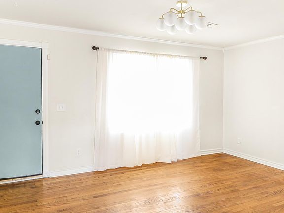 Living room/front door. Updated light fixture and beautiful refinished hardwoods