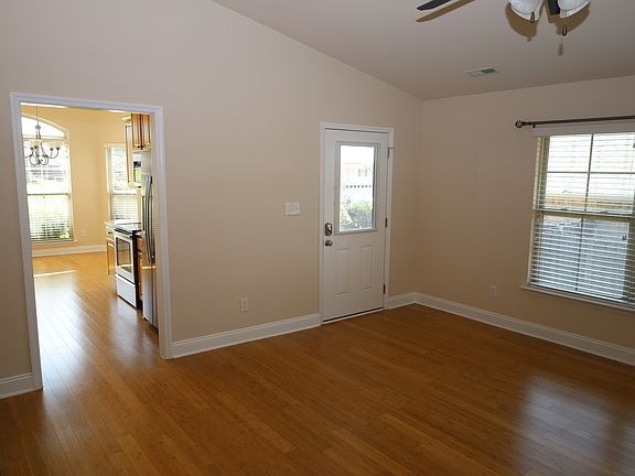 Living room with front door, kitchen is to the left