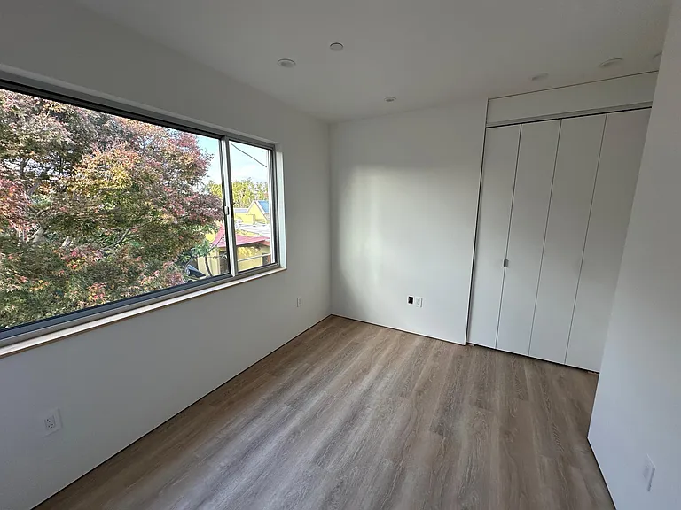 Bedroom #2 enjoys good light and a view of an impressive tree.