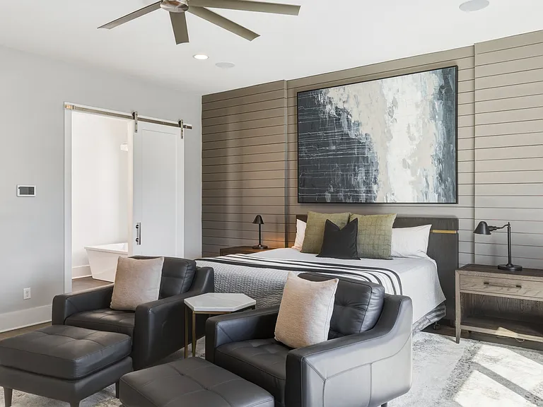 Spacious primary suite featuring a plush king bed, cozy seating area, walk-in closet with custom built-ins, spa-like bath, smart TV and private access to an 11x9 deck. Your private retreat to unwind in comfort.