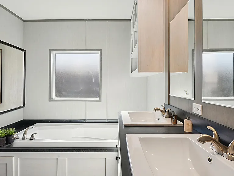 Spacious ensuite bathroom featuring dual sinks, a relaxing soaking tub, and modern finishes.