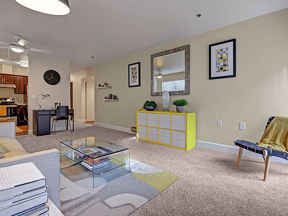 Living room with couch, desk, and view into the kitchen