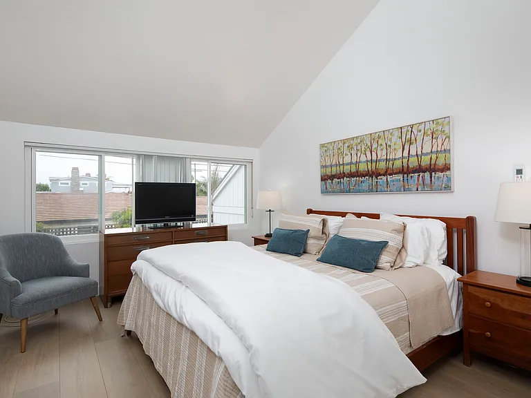 Upstairs primary bedroom features a king size bed, walk in closet, en suite bathroom and a TV