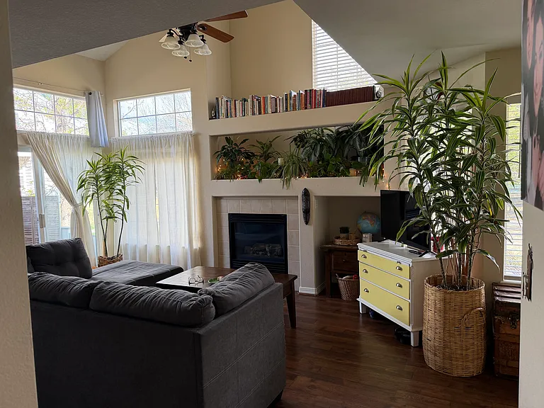 Living room with gas fireplace, tons of natural lighting, and soaring open ceiling for a bright and spacious feel