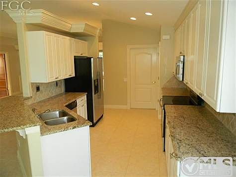 The Kitchen Has Granite Countertops, Stainless Steel Appliances, And Raised White Panels.