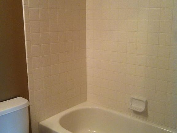 Guest bath with tile tub/shower surround. Vanity with decorator mirror