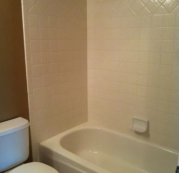 Guest bath with tile tub/shower surround. Vanity with decorator mirror