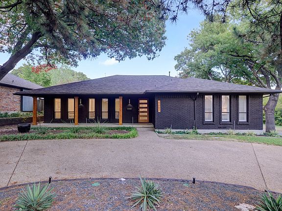Front exterior of home with a circle drive and 2 car garage around the back