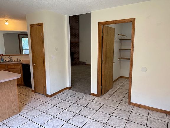 breakfast area looking into entries into pantry (right), living room (center) and kitchen (left)