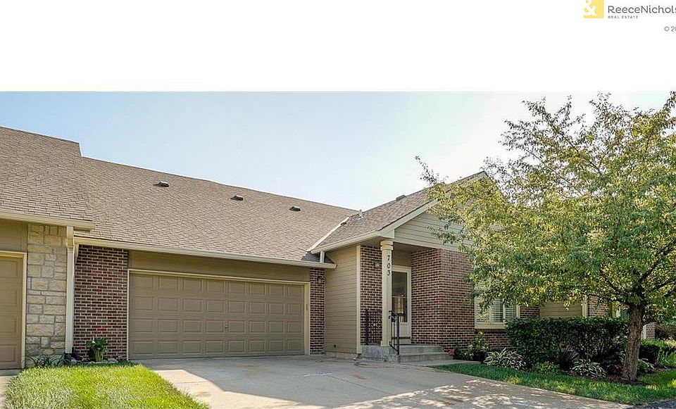 Front view showing two car garage and landscaping.