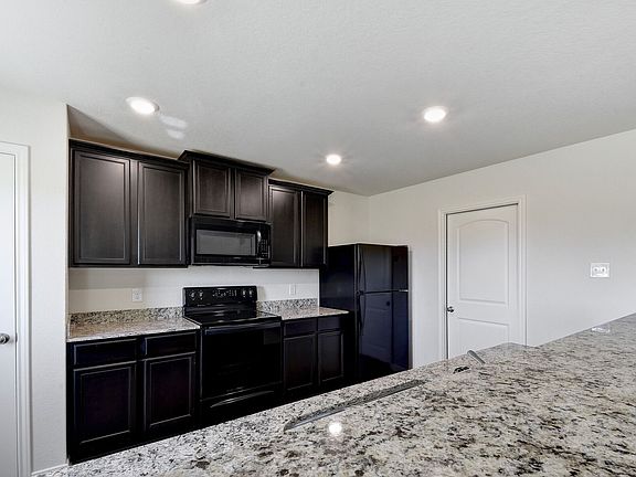 The kitchen showcases stunning wood cabinetry and granite countertops.