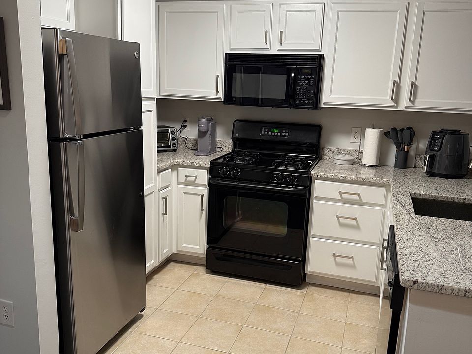 Kitchen with new fridge and gas stove.