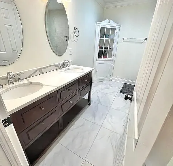 Primary bathroom with dual vanities and walk-in shower