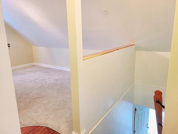 View of stairs, front door, and living room