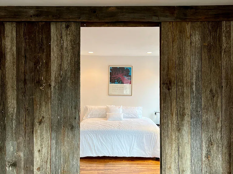 Barn doors separate the king-size bedroom from the office/guest bed space.