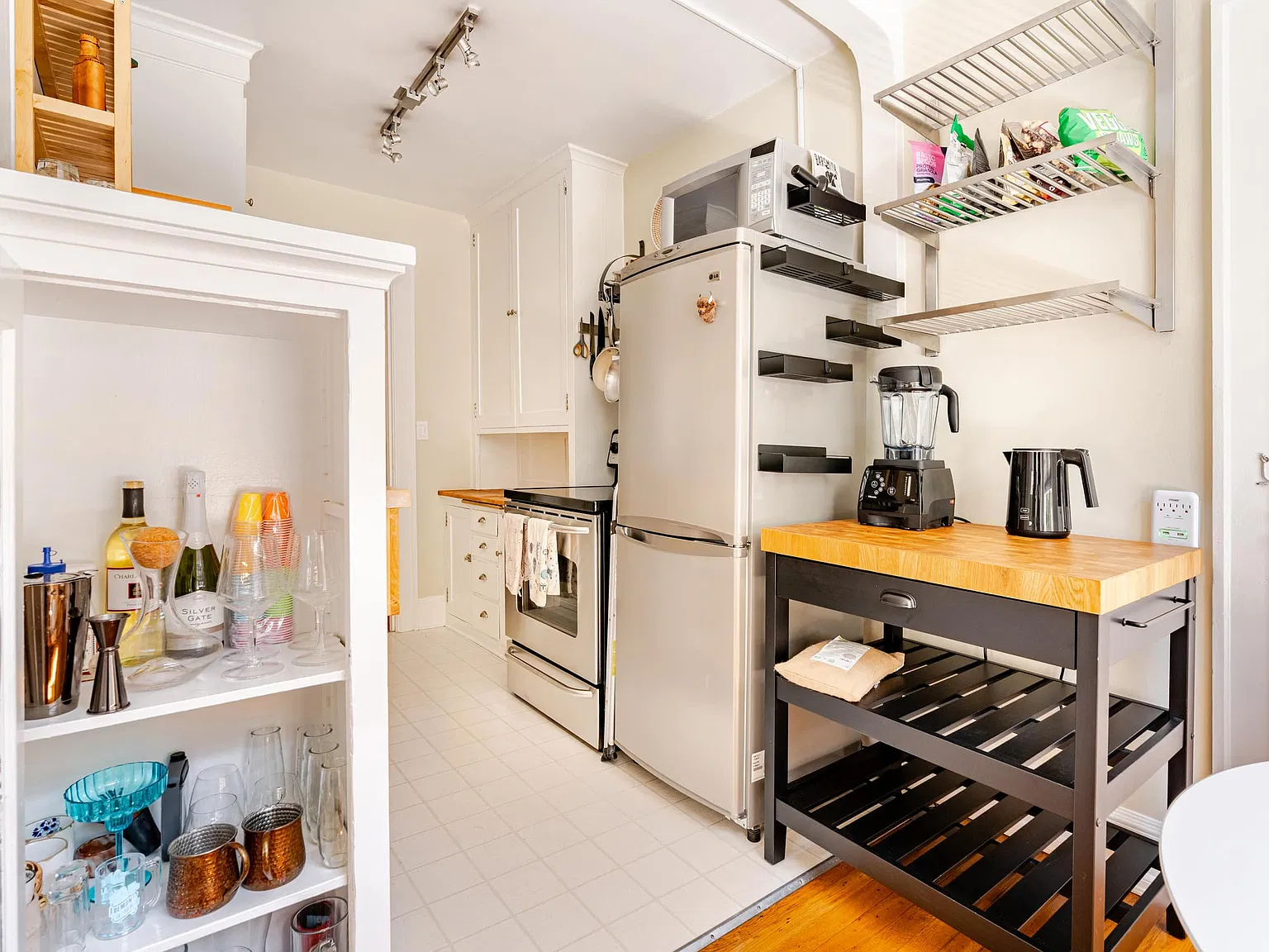 Kitchen: full-size fridge, open shelving and a butcher-block cart
