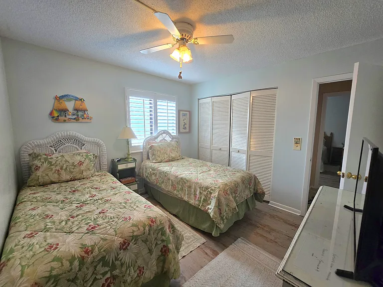 Twin guest bedroom with a large closet and 32 inch Samsung TV with ROKU