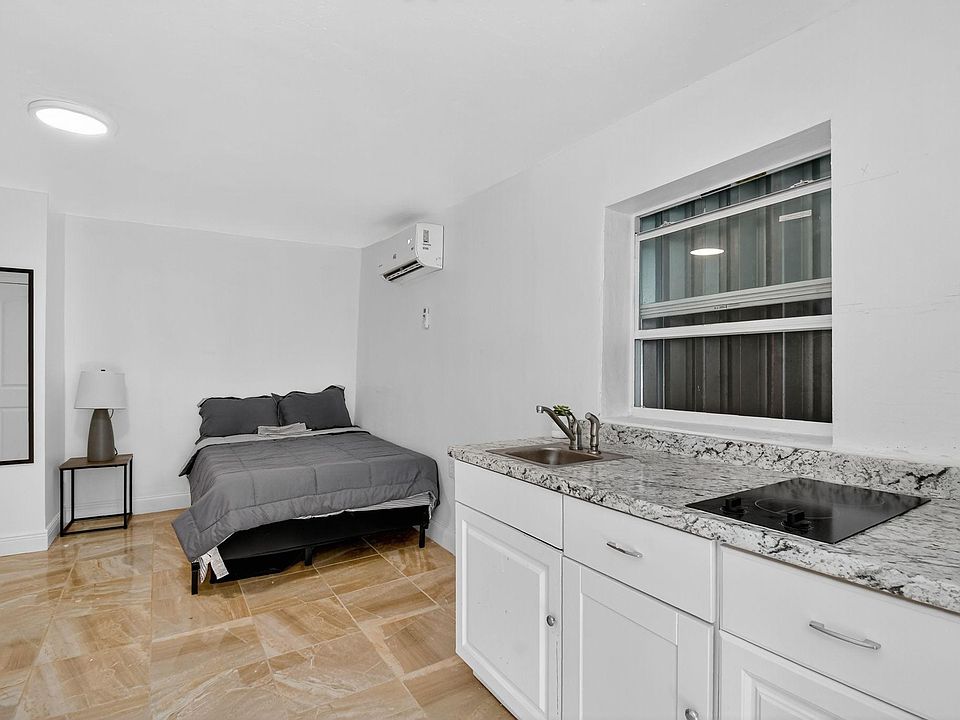 Private sleeping area with a kitchenette featuring granite-look counters, sink, cooktop, and in-room A/C for comfort.