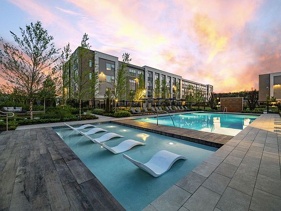 Resort-style pool featuring both in-pool sun loungers and day beds