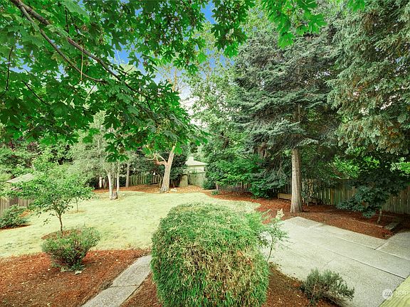 Rear yard also has a nice sized patio. If you have a green thumb you'll love this yard. It's park like!!>