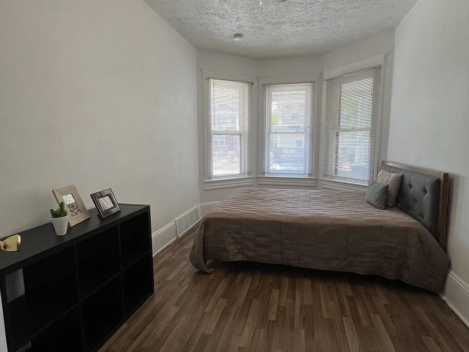 Large Inviting Bedroom w/ Sun filled Bowed Windows, Tall Ceilings, Rich Hardwood Floors & Ceiling Fan