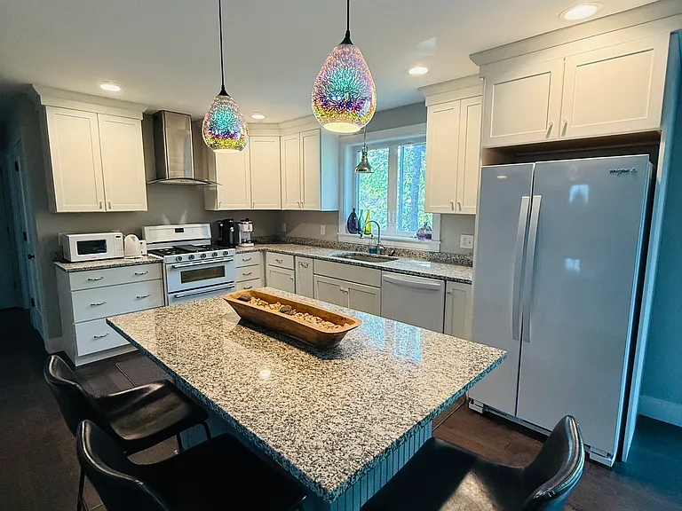 Kitchen with marble-top counters and island.