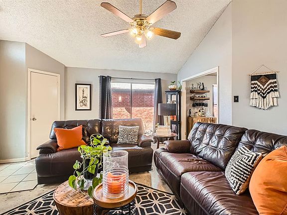Living room featuring a ceiling fan and vaulted ceiling.