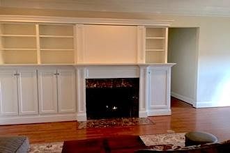 View of Fireplace cabinetry. Note Panel door above Fireplace. The Panel door is closed in this photo.