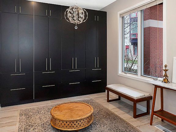 This gorgeous office/mud room welcomes guests to your new home with custom built-ins, a chandelier &
