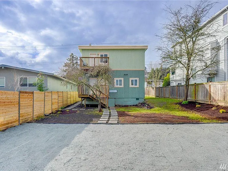 Back of house. Garden beds and patio exist in place of mulch. We have painted the house since this picture was taken. This also shows the expansive driveway.