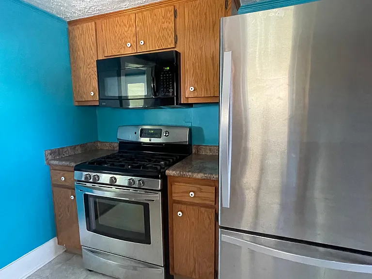 Large refrigerator with ice maker. Natural gas cooking stove.