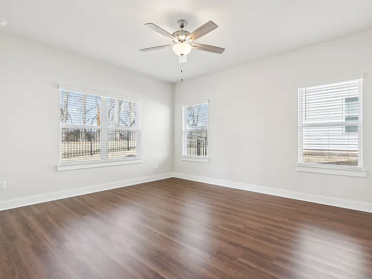 Bedroom with wood floors and a ceiling fan.