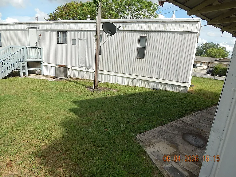 View from storage building (on the right) showing north side of home with deck at house entrance