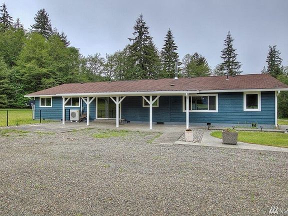 Back of home with covered patio through slider off kitchen and plenty of parking space. 