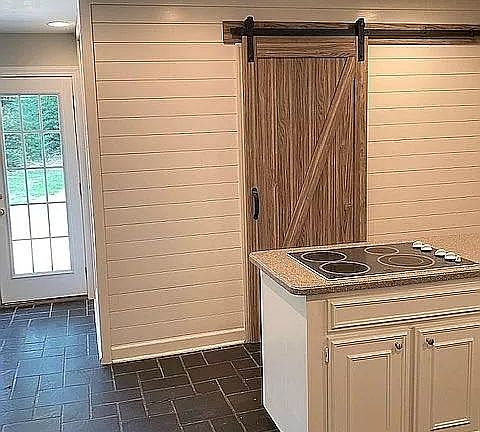 Kitchen looking toward back yard. Laundry room behind barn door