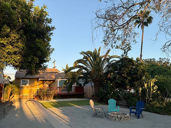 Mid yard perspective of house and firepit during golden hour